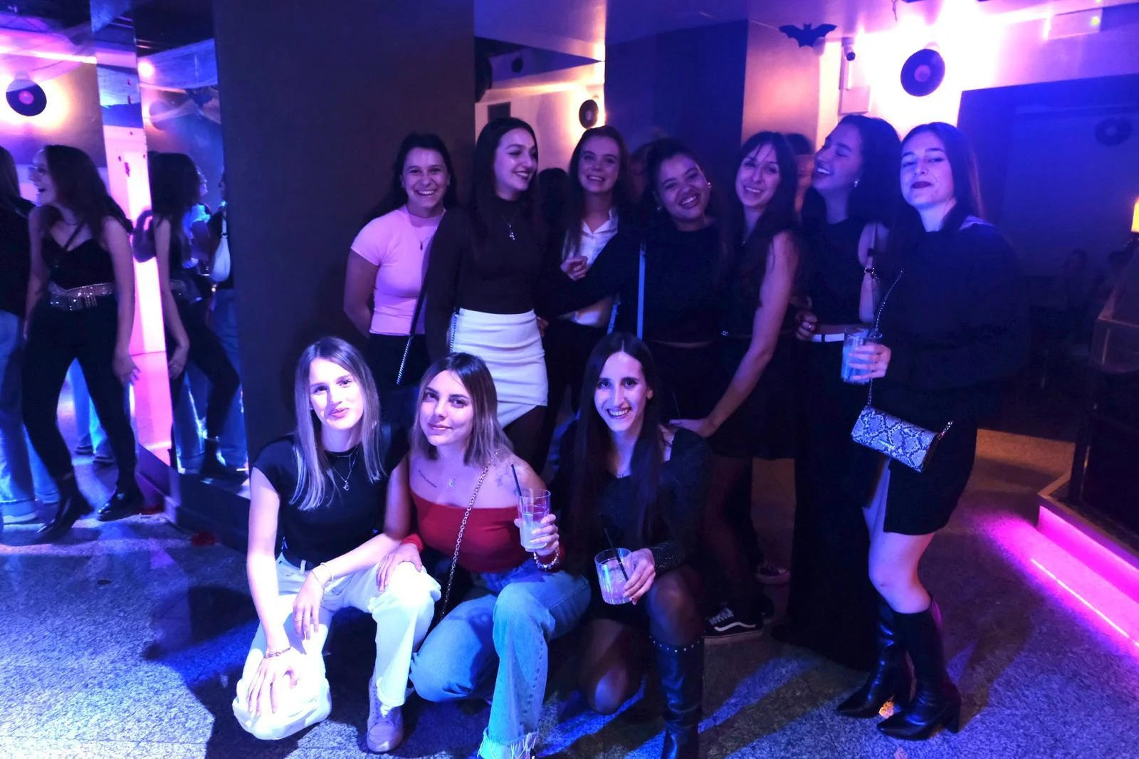 Gruppo di amiche in posa sotto le luci viola della pista Gruppo di amiche in posa sotto le luci viola della pista